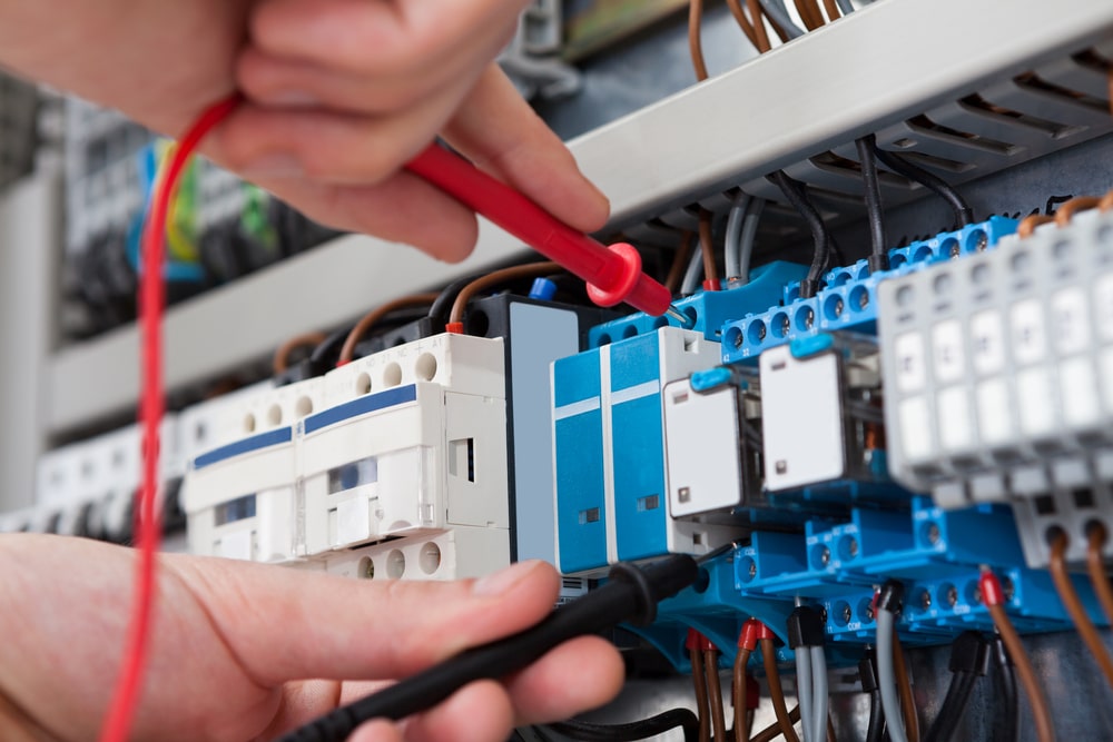An electrician investigating a faulty switch board